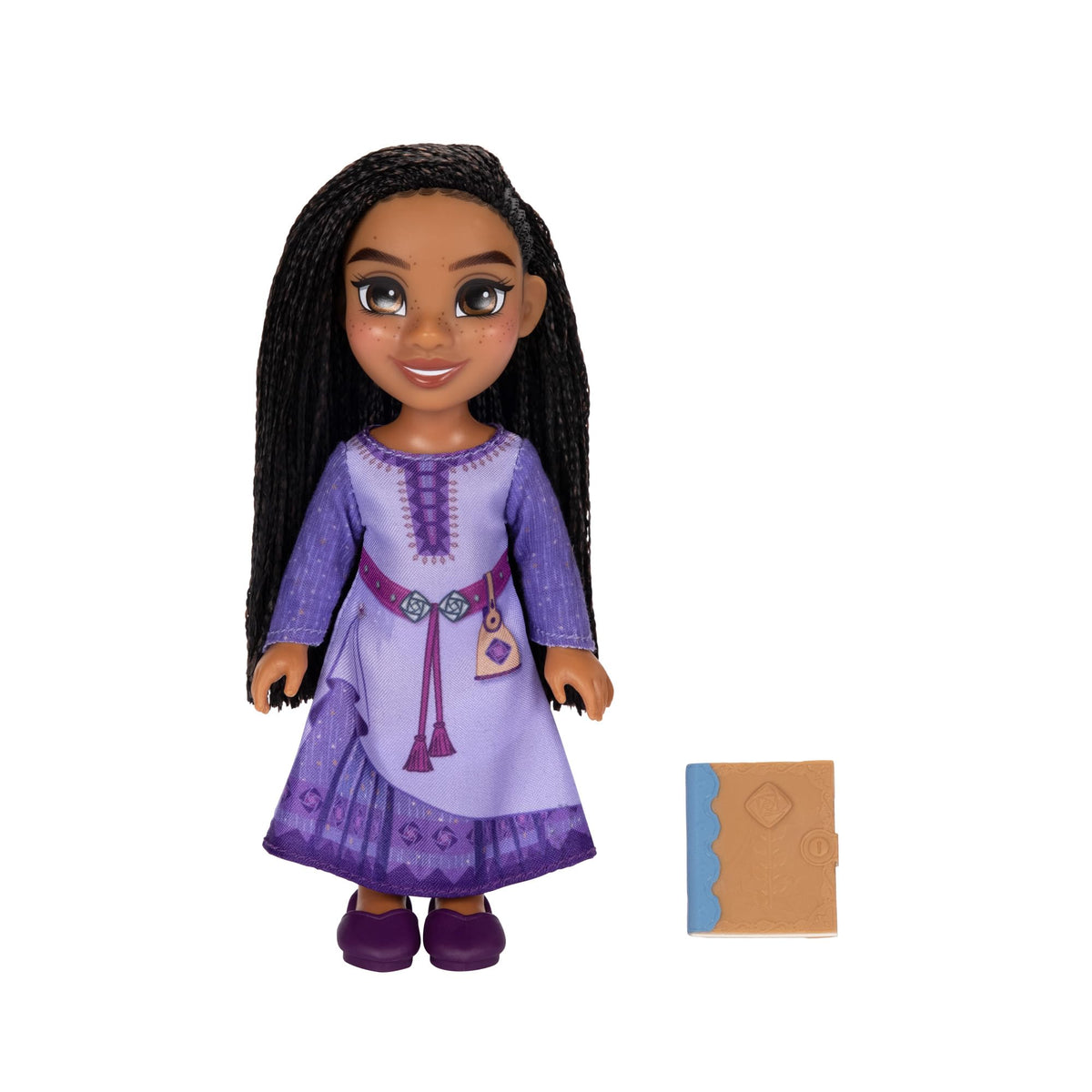 6 inch doll with long black braids and freckles in a lilac tunic, beside a small tan book accessory