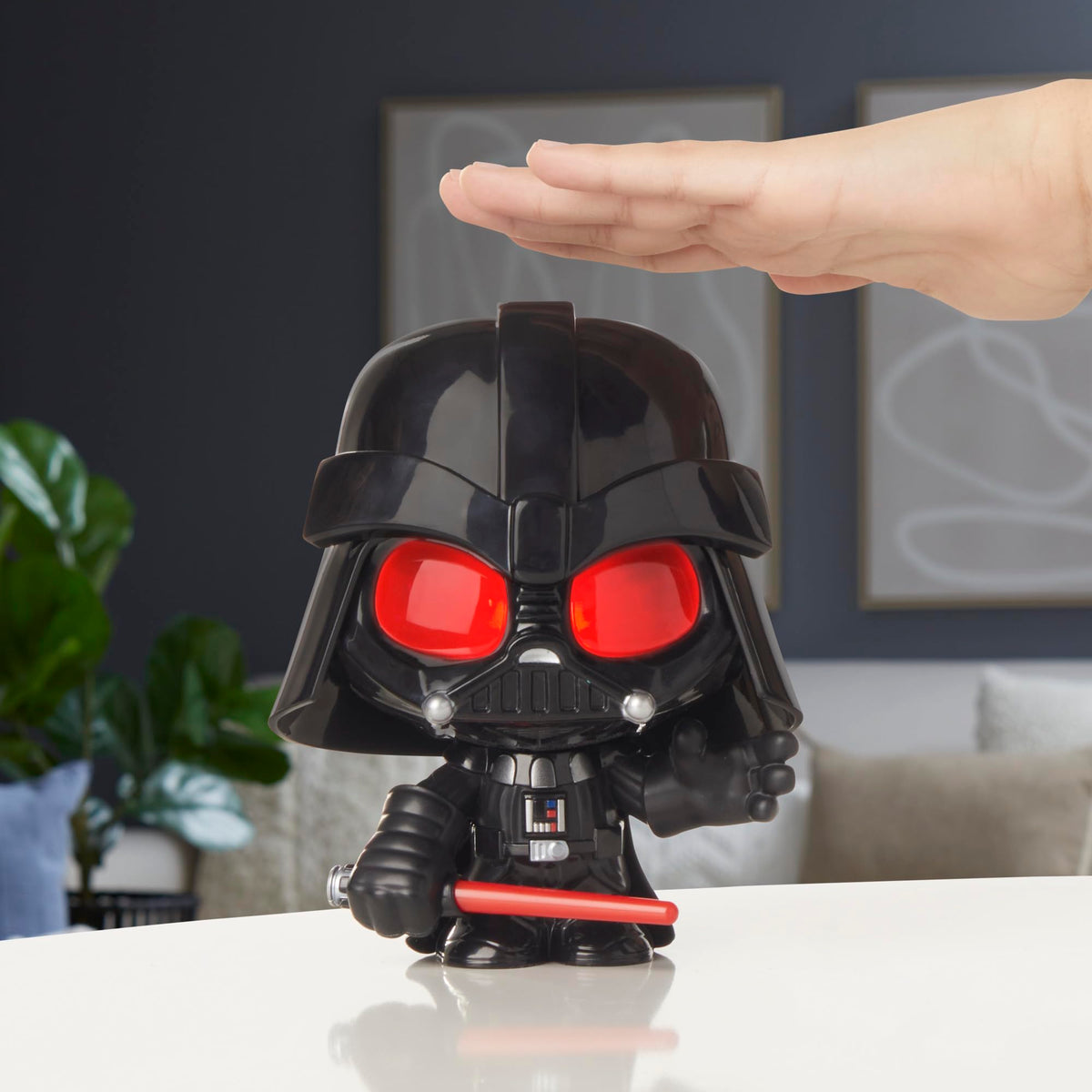 Hand pressing down on the helmet of the figure as its red eyes light up