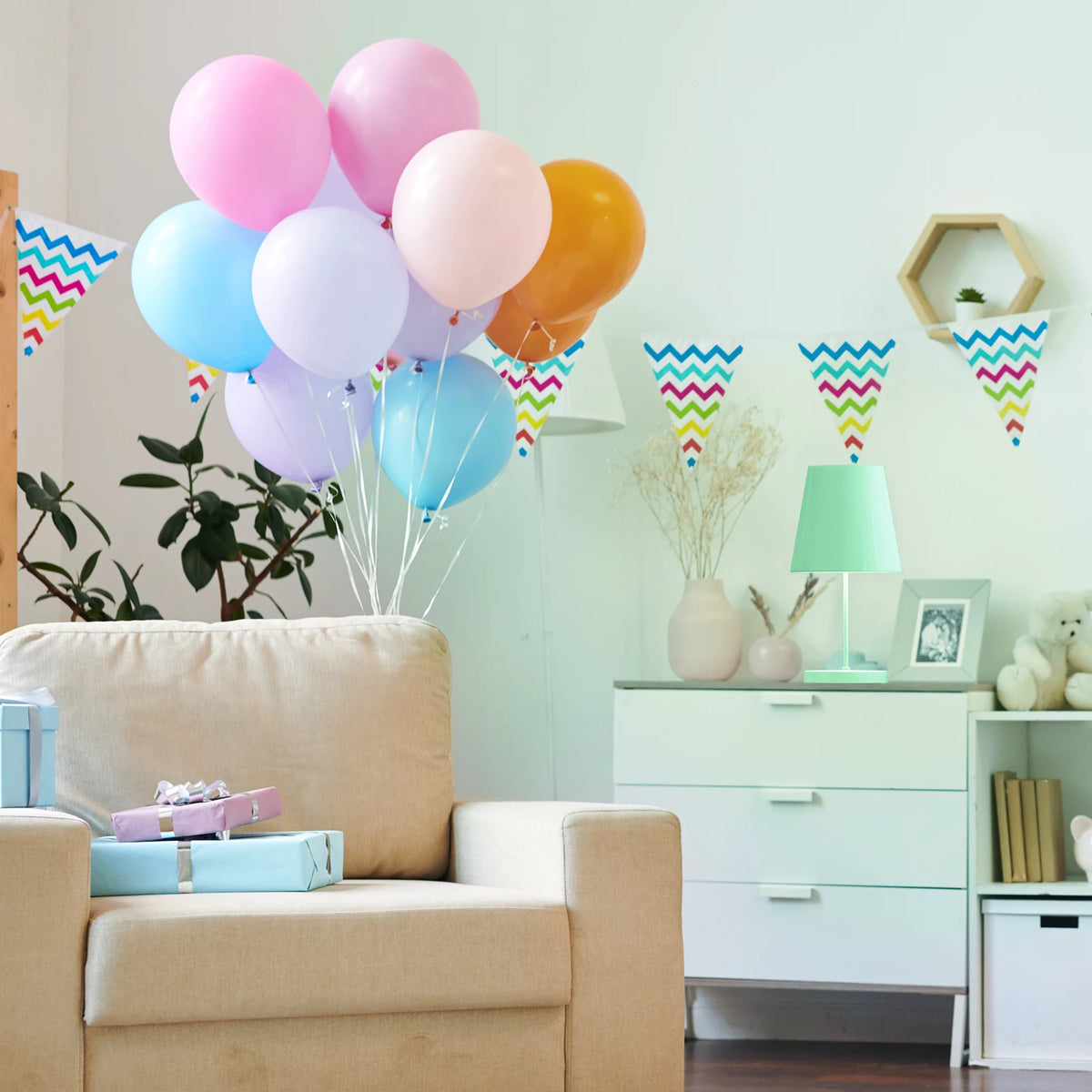 Party room with pastel balloons and bunting lit by a green table lamp