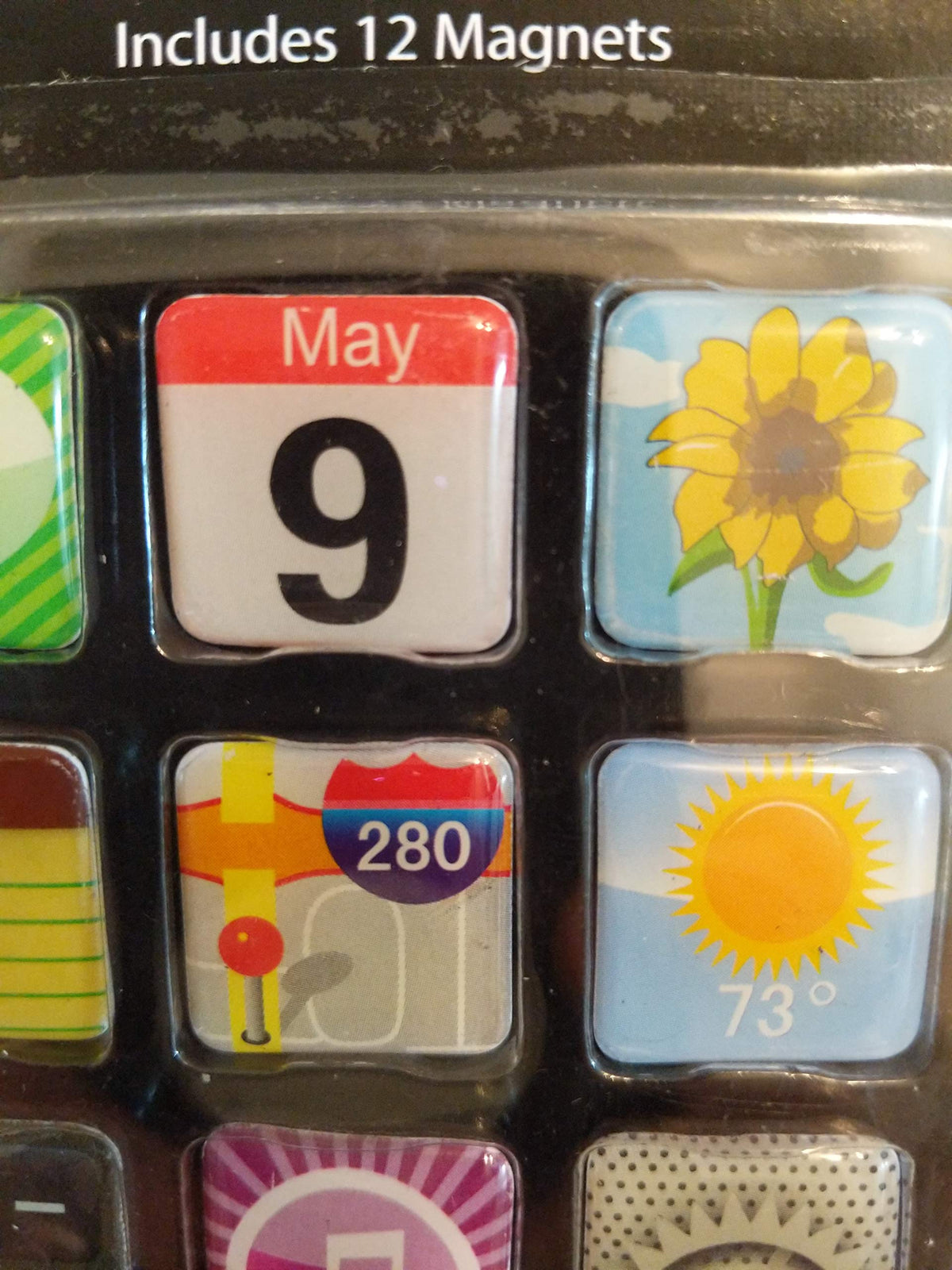 Close-up of the calendar, sunflower, map and sunny weather icon magnets in their blister