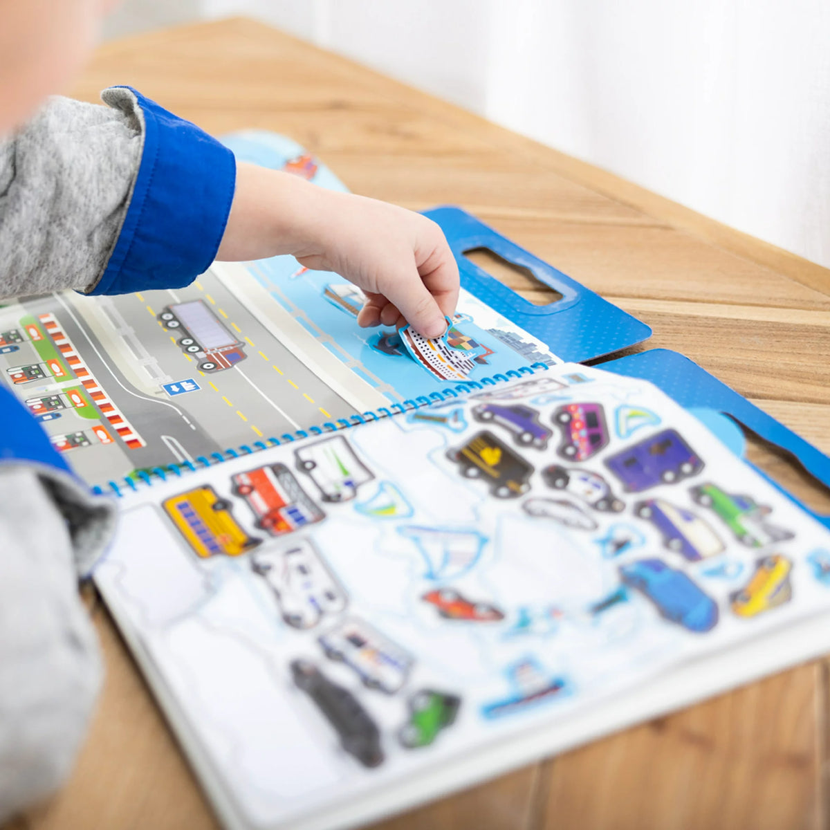 Child placing a cruise ship sticker on a harbor scene from the vehicle sticker pad