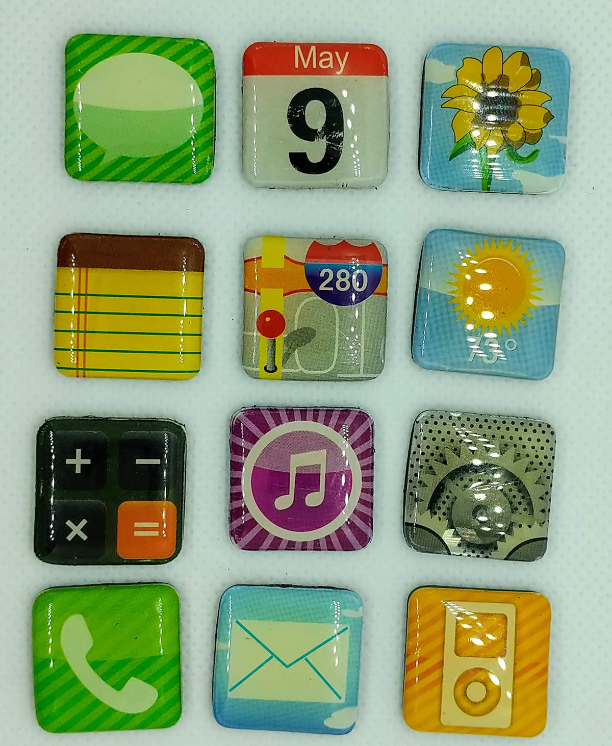 Twelve loose glossy square magnets printed with messages, calendar, notes, calculator and music icons