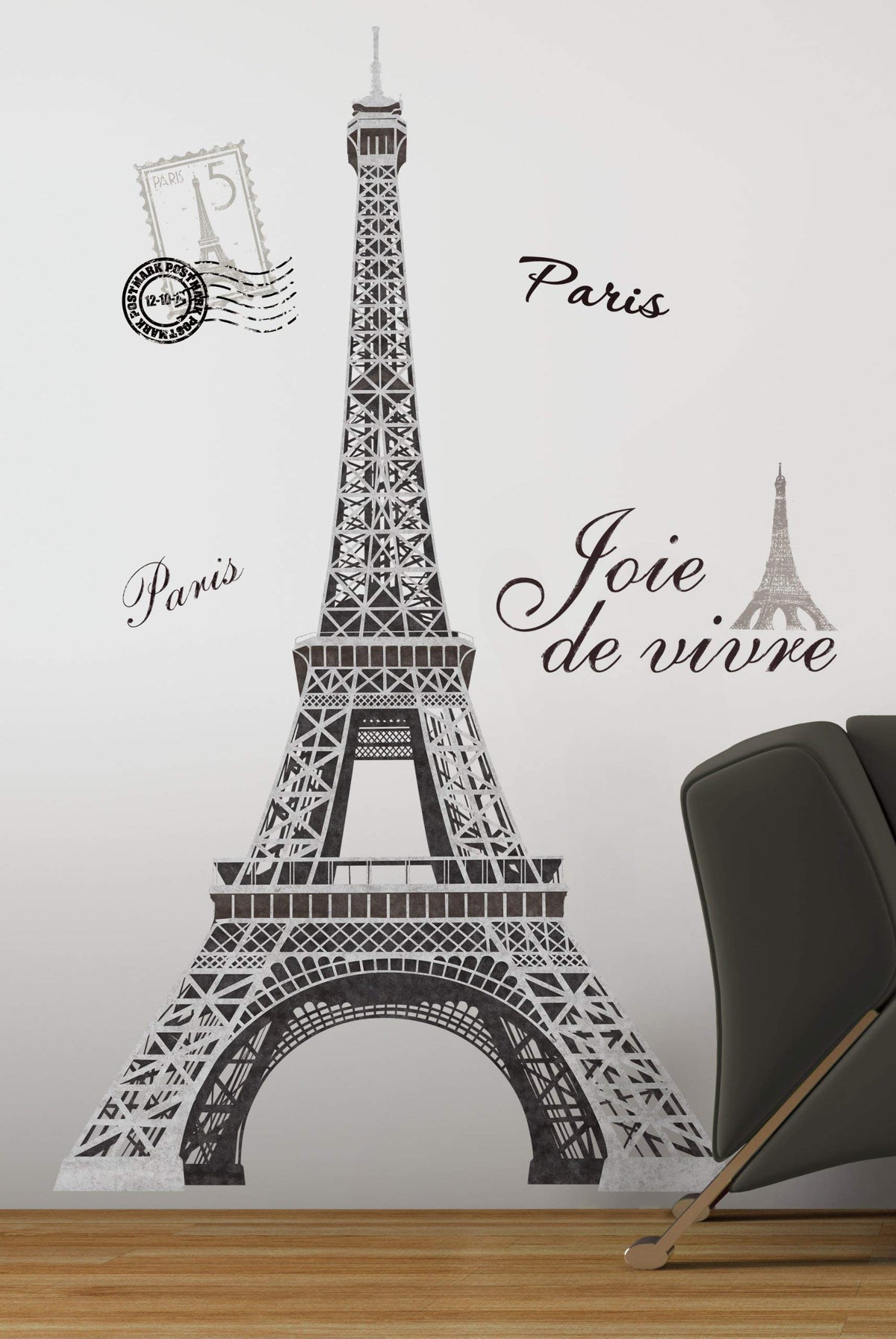Giant black and grey Eiffel Tower wall decal with Paris script, stamps and Joie de vivre beside a chair
