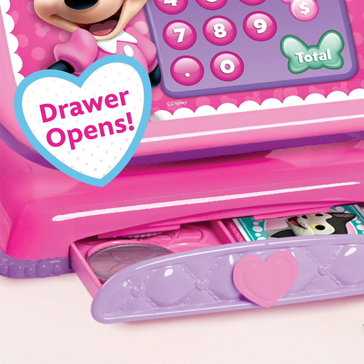 Close-up of the Minnie cash register's purple money drawer sliding open with play coins and notes