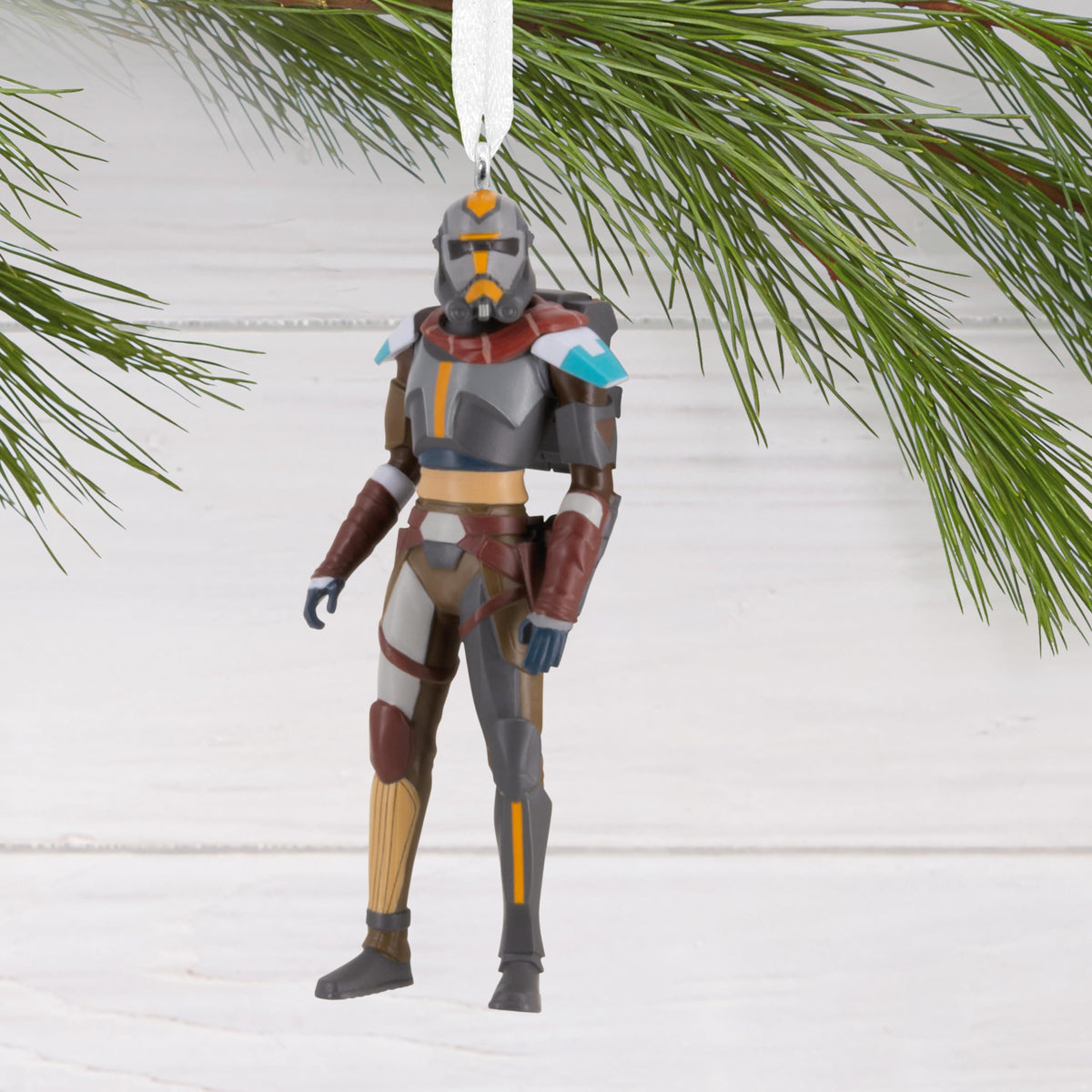 Armoured soldier ornament with a red scarf hanging from a pine branch