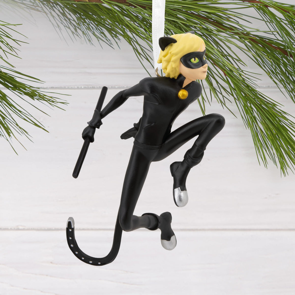 Leaping cat hero ornament hanging from a pine branch