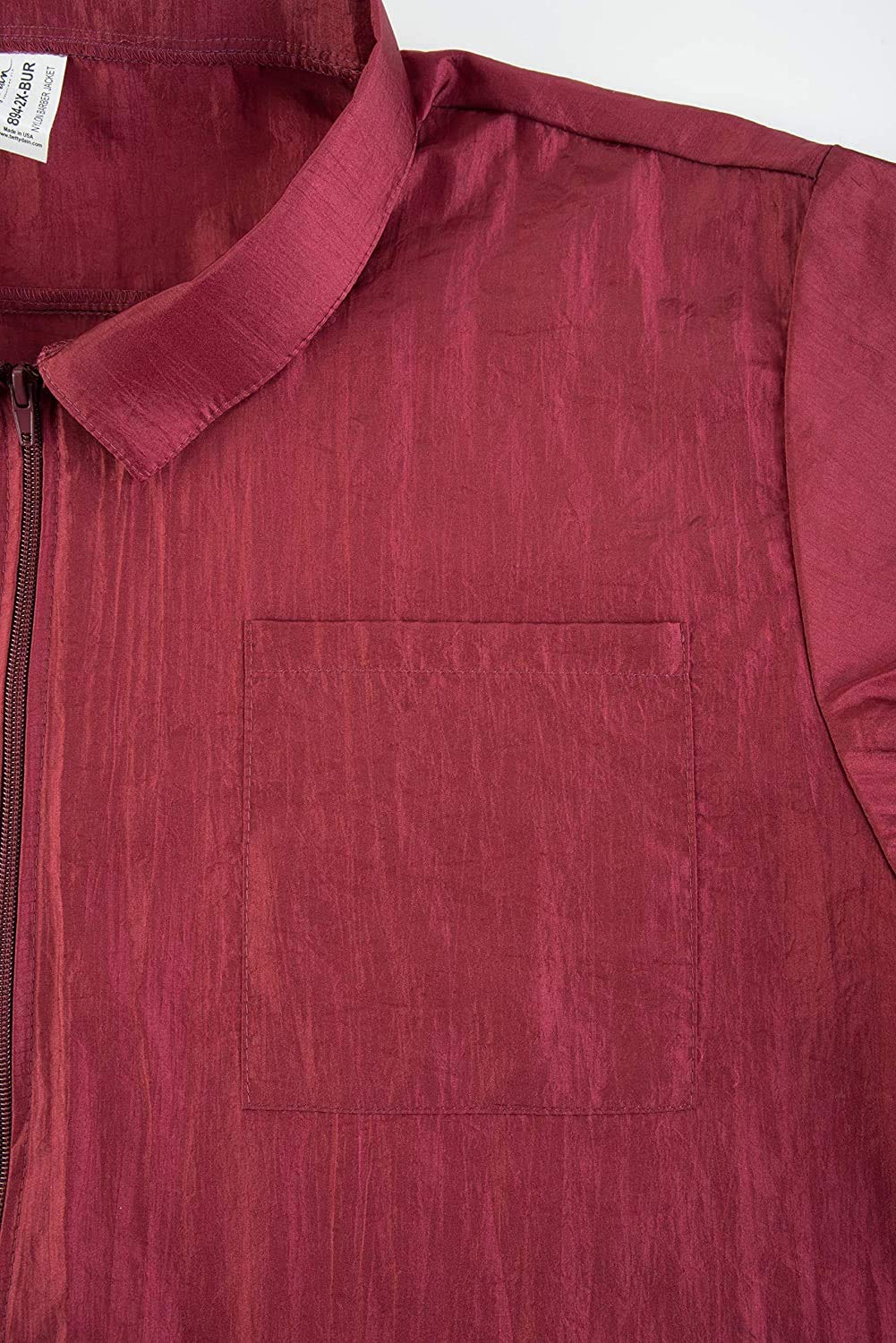 Close-up of the square chest pocket on the shiny burgundy nylon jacket