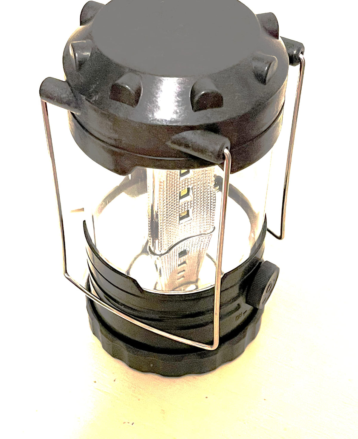 Black collapsible LED camping lantern with wire carry handle and side dial