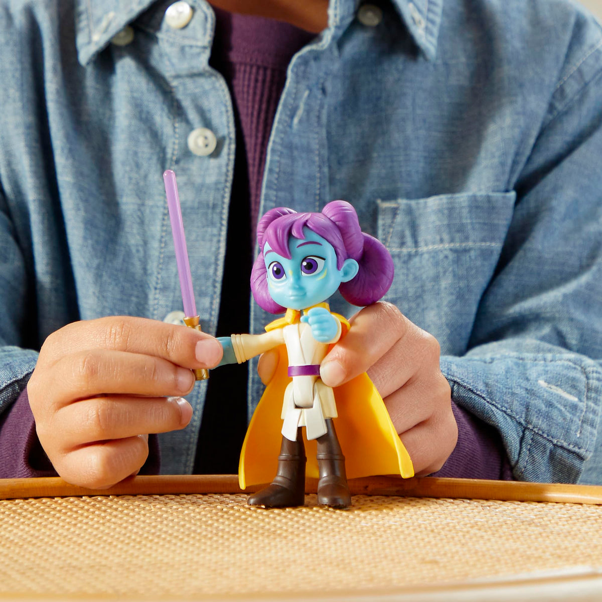 Close-up of hands holding the purple-haired figure and its purple lightsaber
