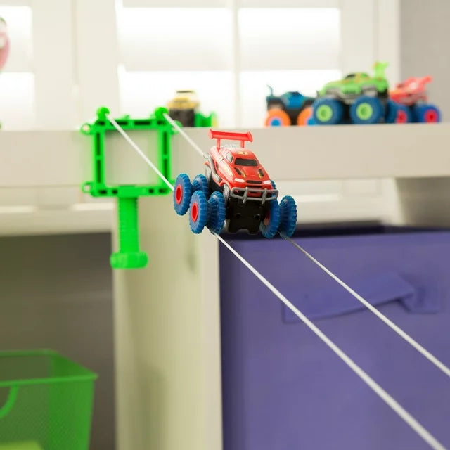 Red monster truck climbing a string track from a shelf with a green winch