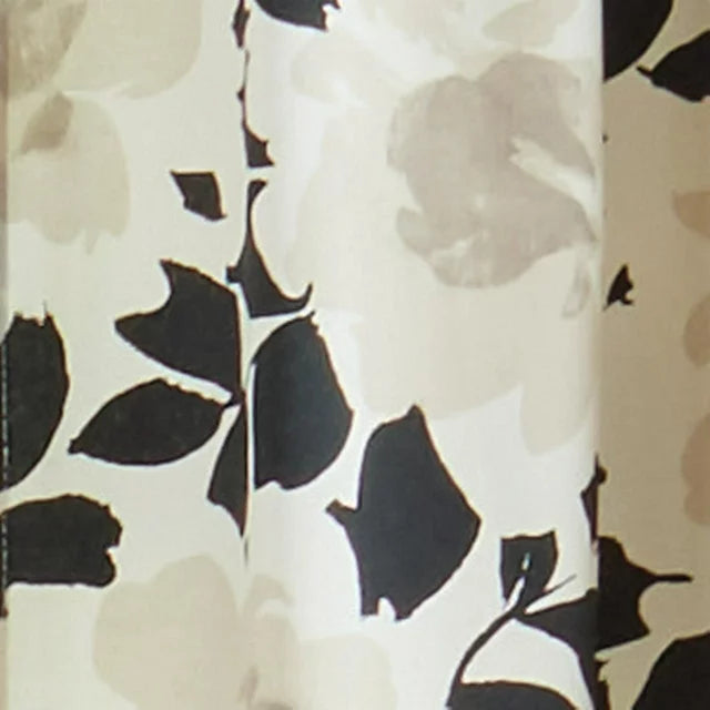 Close-up of black leaves and soft beige blooms on cream fabric