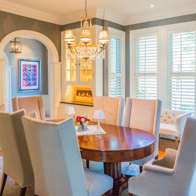 Crystal chandelier with small shades over a wood dining table