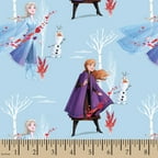 Light blue fabric printed with Anna, Elsa and Olaf among bare white trees, by a ruler