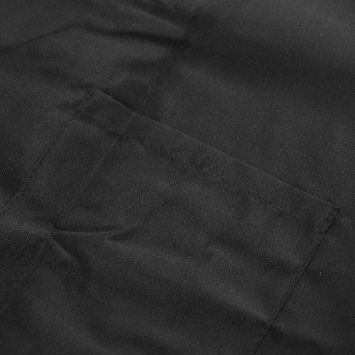 Close-up of the stitched patch pocket on black poly nylon fabric