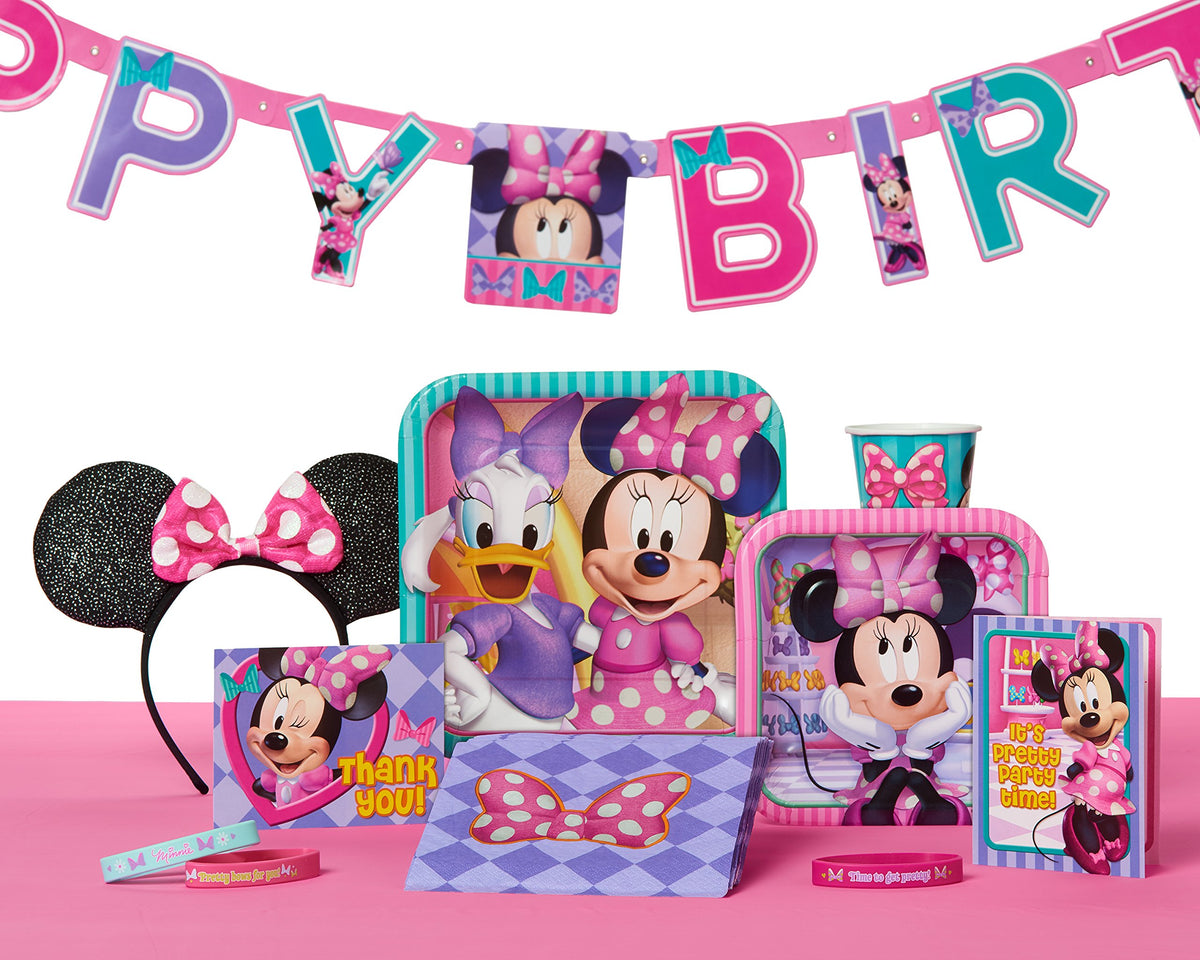 Minnie Mouse party table with plates, cup, napkins, ears headband, wristbands and birthday banner