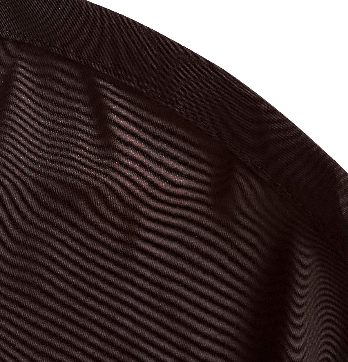 Close-up of the curved stitched hem on the chocolate brown apron