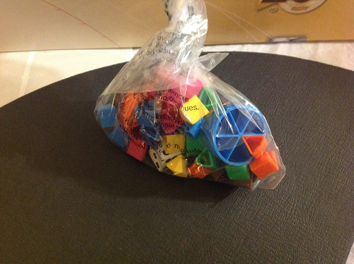 Clear bag of coloured scoring wedges, round tokens and a white die