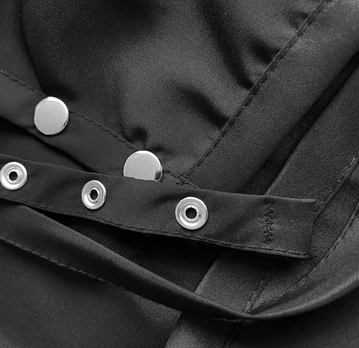 Close-up of the silver snap neck strap on the black apron
