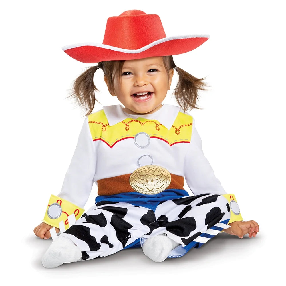 Smiling toddler in a red cowgirl hat and jumpsuit with yellow yoke, gold buckle and cow-print chaps