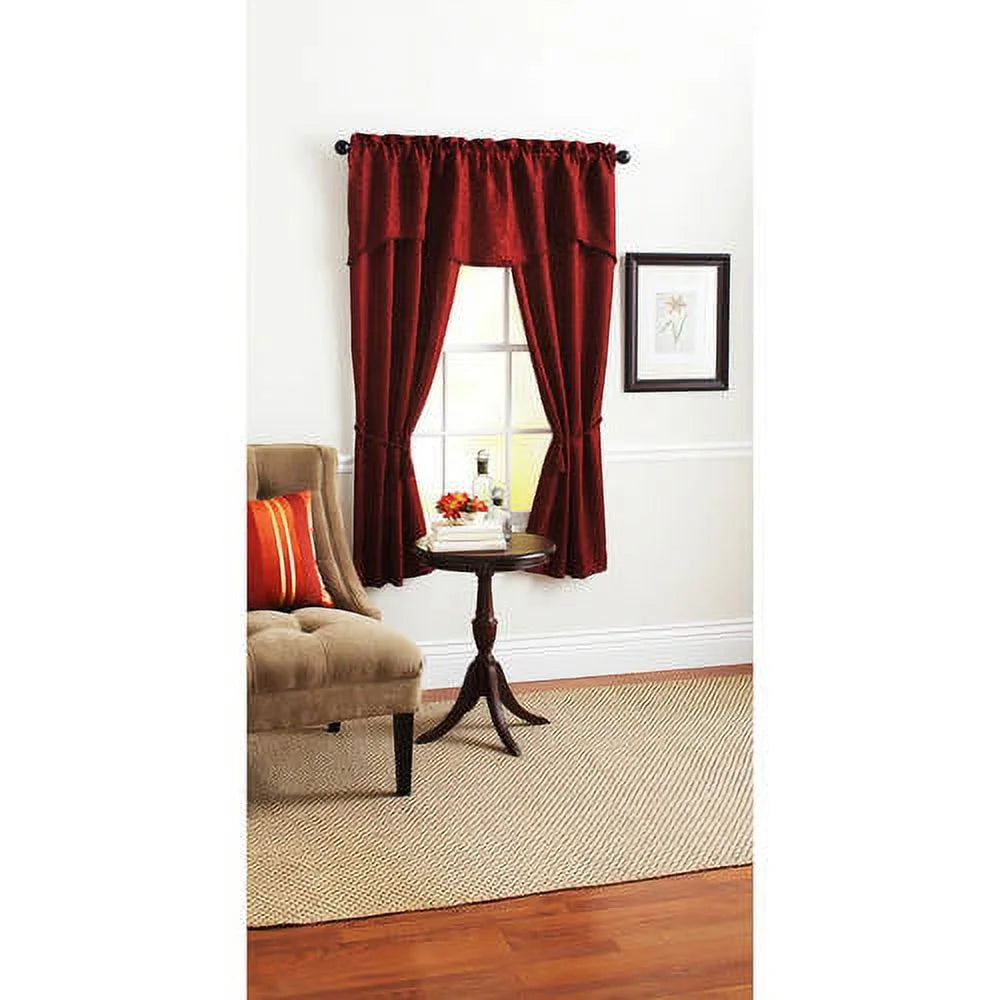 Burgundy damask curtain panels and valance tied back on a window beside a beige armchair