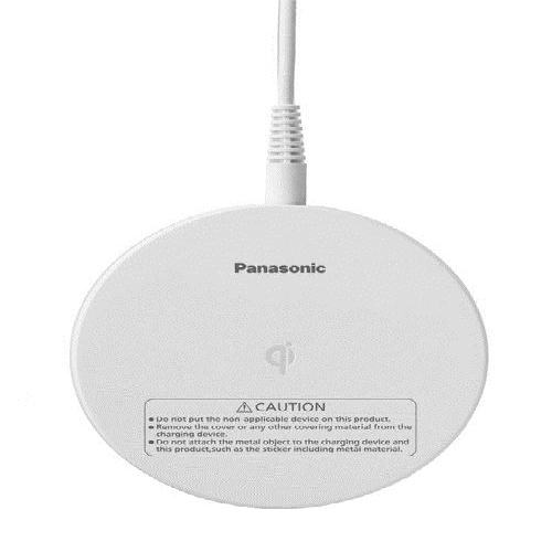 Round white wireless charging pad with a white cable and caution label