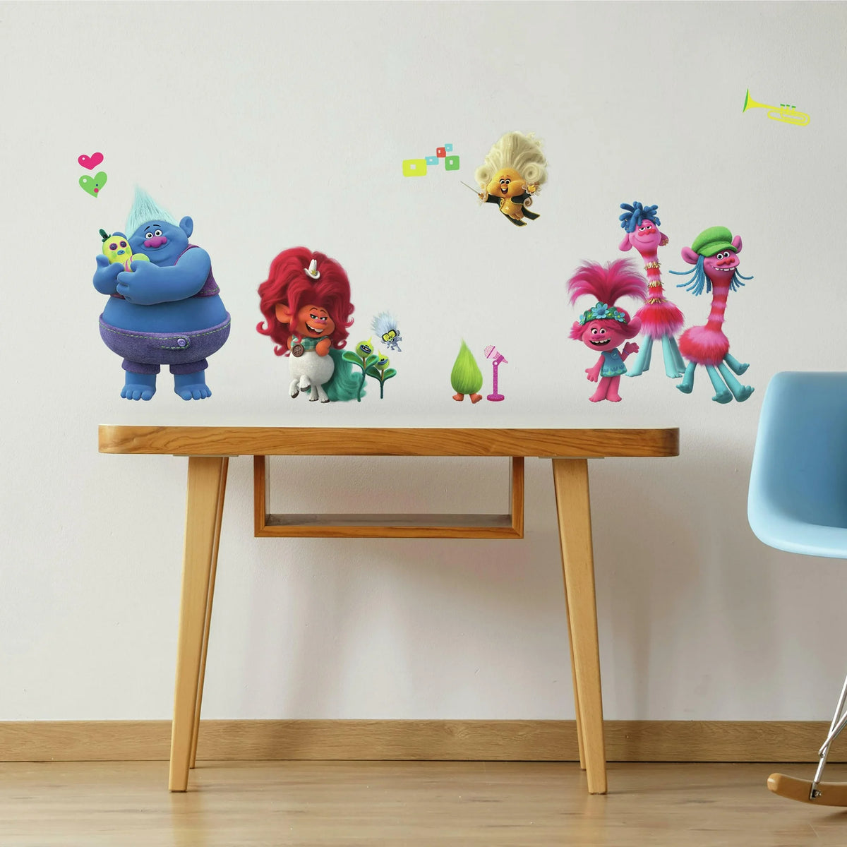 Colourful troll character wall decals above a wooden kids' table