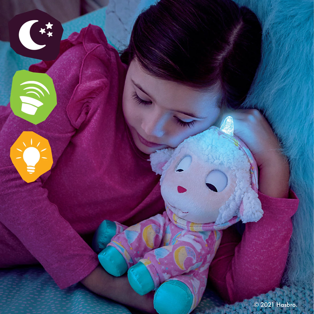 Girl cuddling the sleepy lamb plush at night with its horn lit up