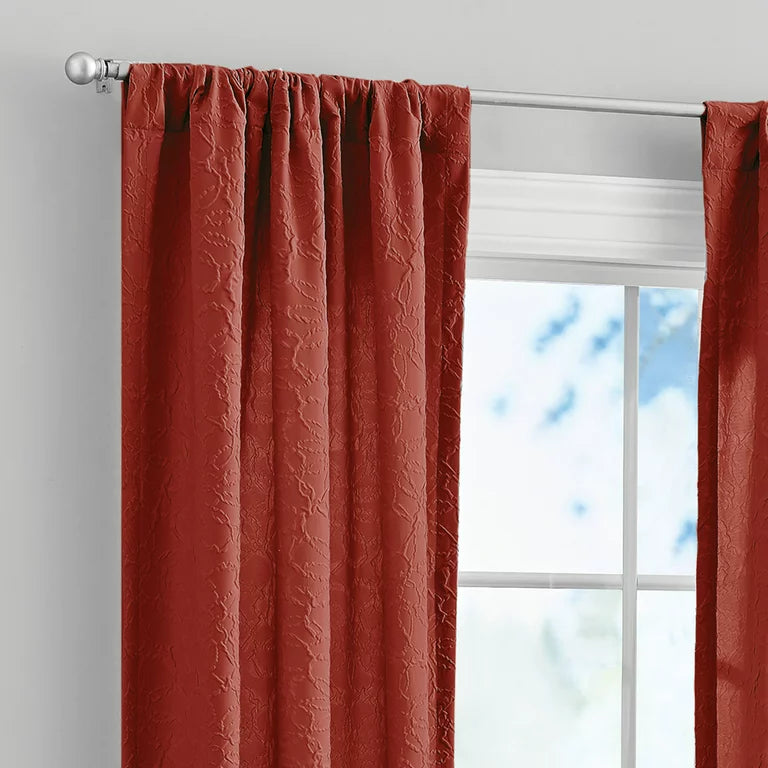 Rod pocket top of the rust red embossed curtain on a silver rod