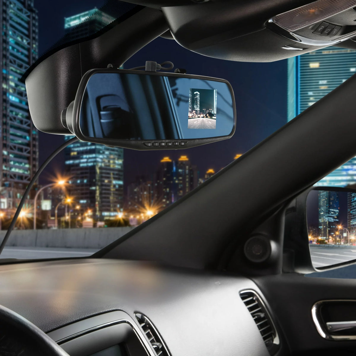 Mirror dash cam in a car at night with city lights on its screen