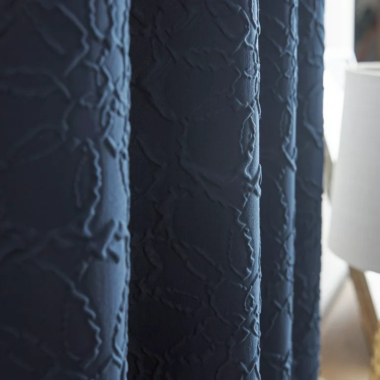 Close-up of the navy curtain's raised floral sculpted texture