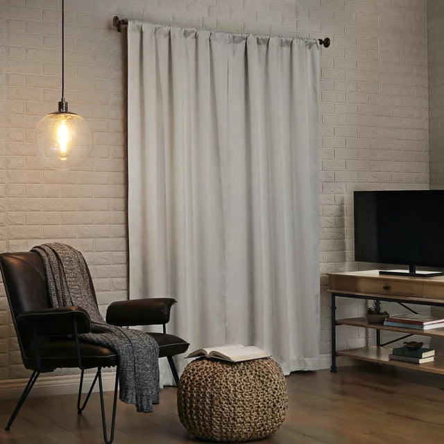 Single pearl curtain panel against a white brick wall beside a TV stand