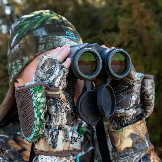 Hunter in a camo beanie and camo flip-top gloves looking through binoculars