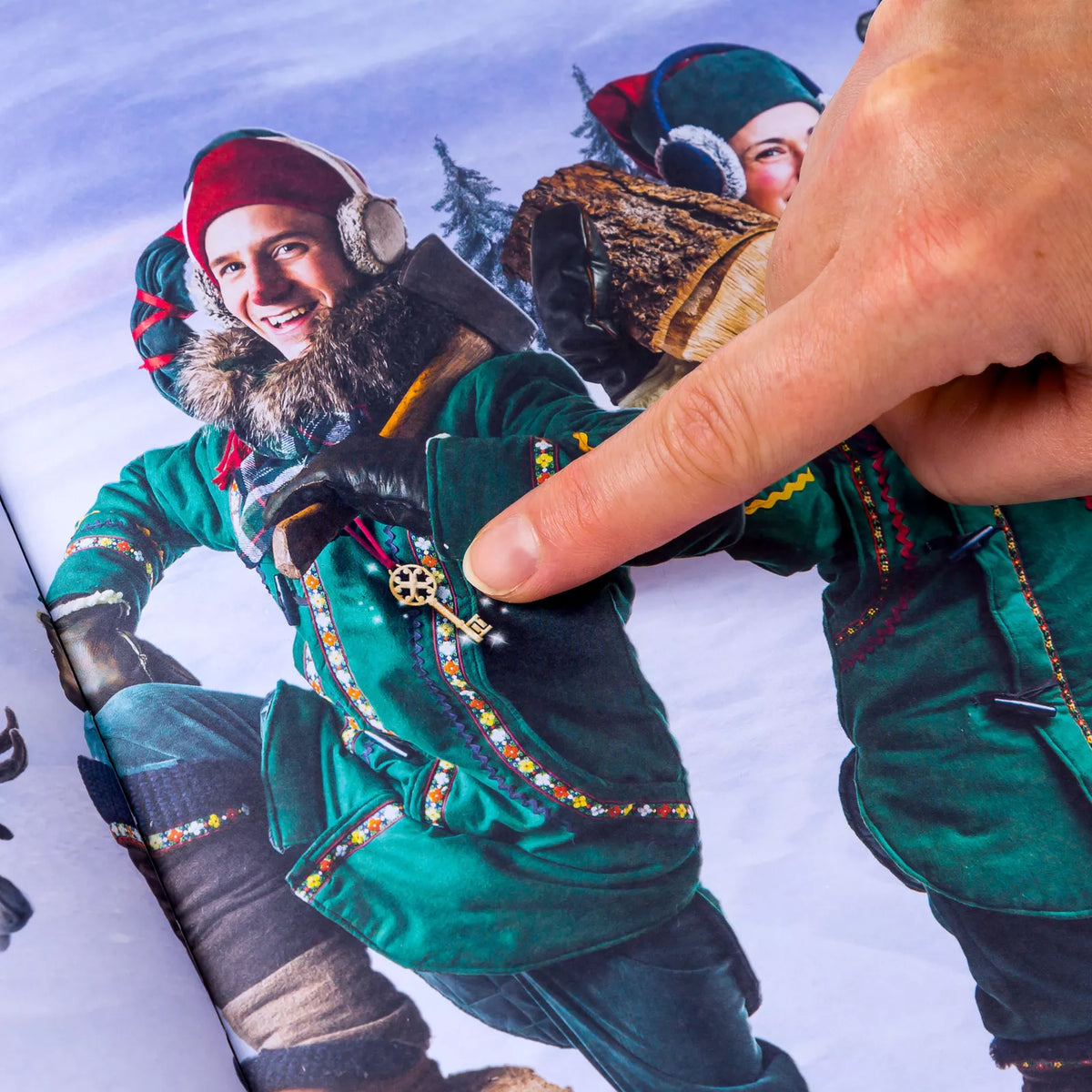 Finger pointing to a hidden golden key on an elf's green coat in the storybook