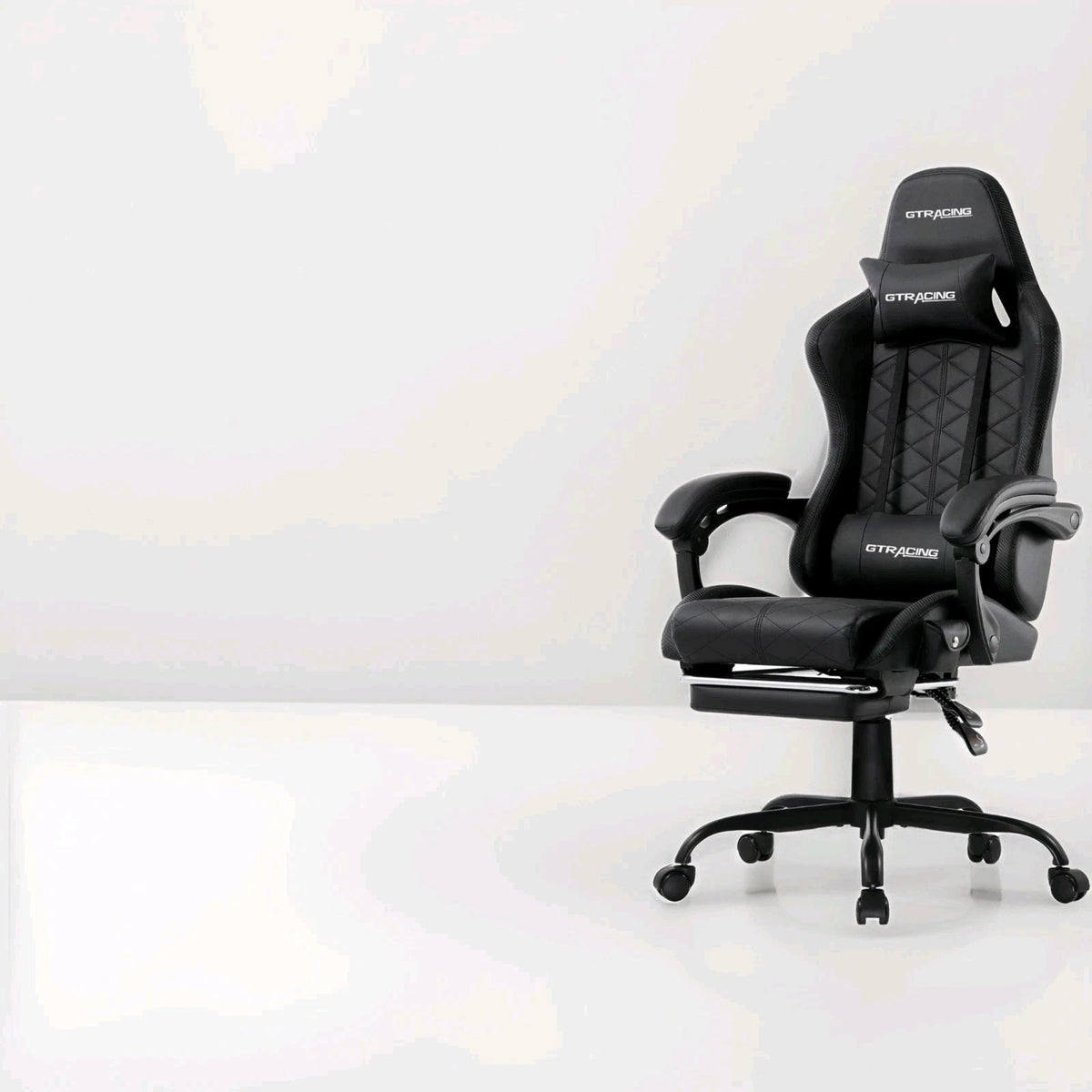 Black reclining gaming chair on a white floor against a pale wall