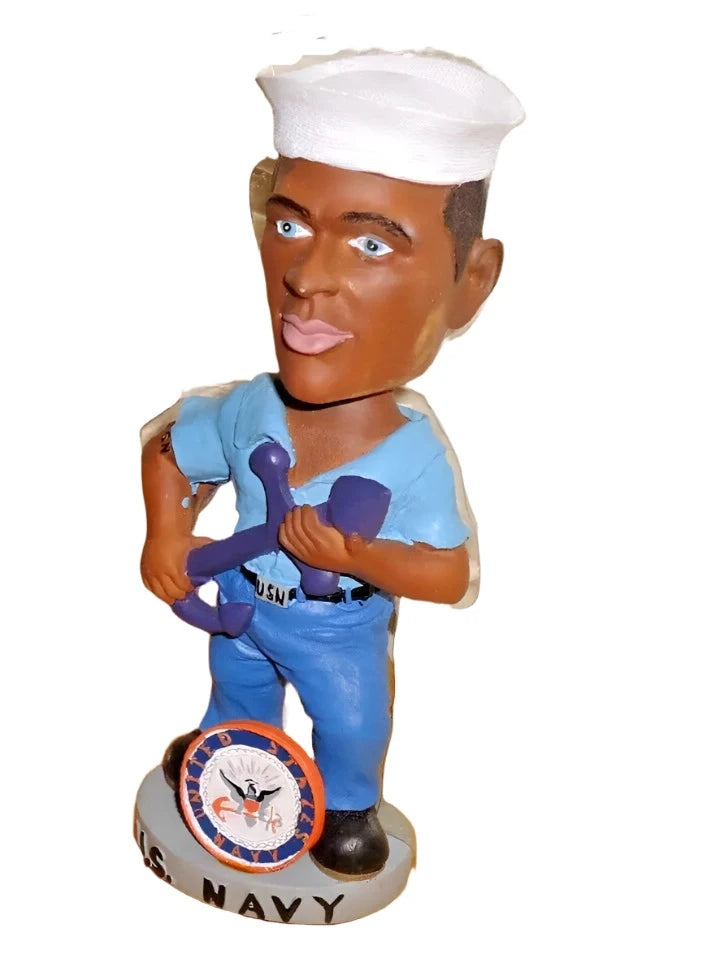 Angled view of the sailor bobblehead gripping a purple anchor