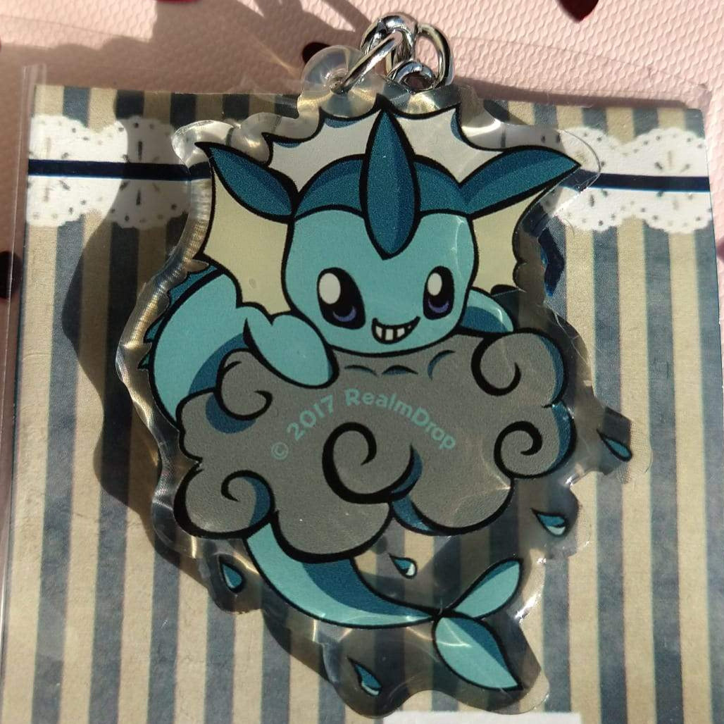 Grinning Vaporeon on a grey rain cloud acrylic keychain, fish tail curling below