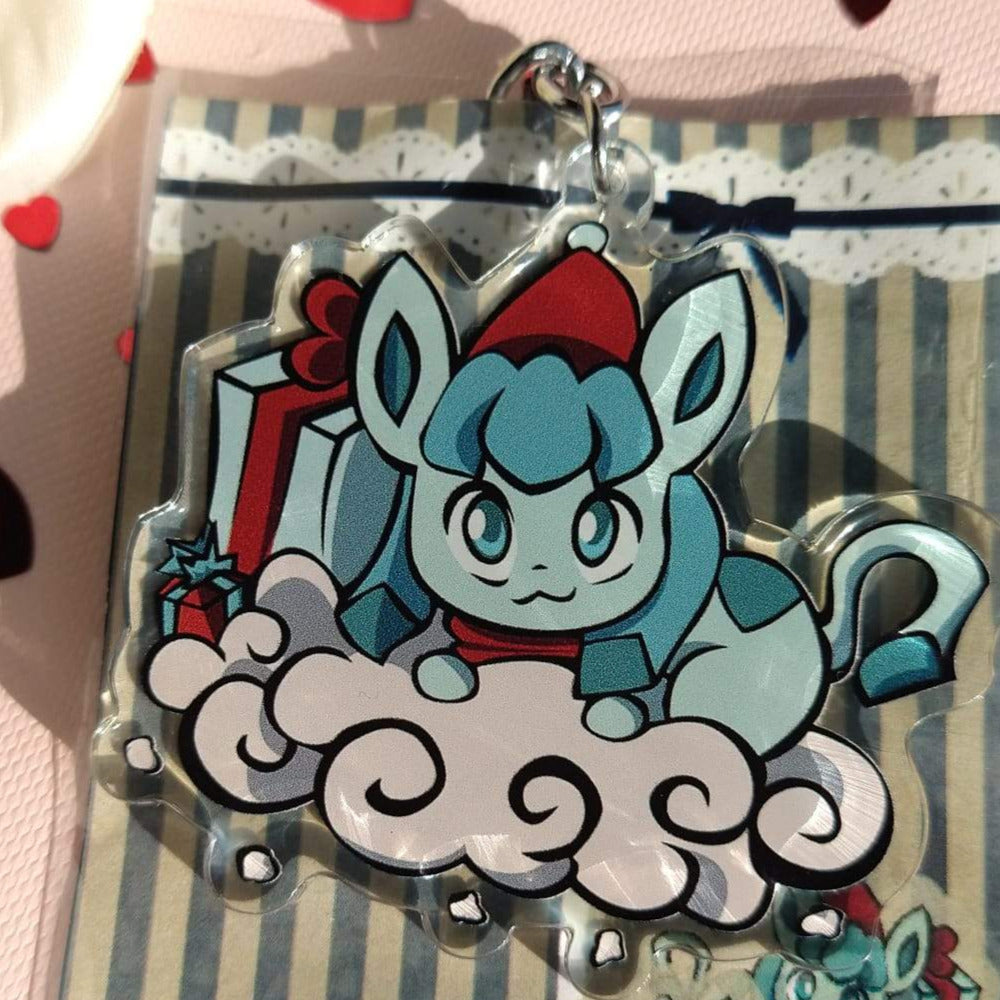 Acrylic Glaceon keychain in a red Santa hat on a snow cloud with gift boxes