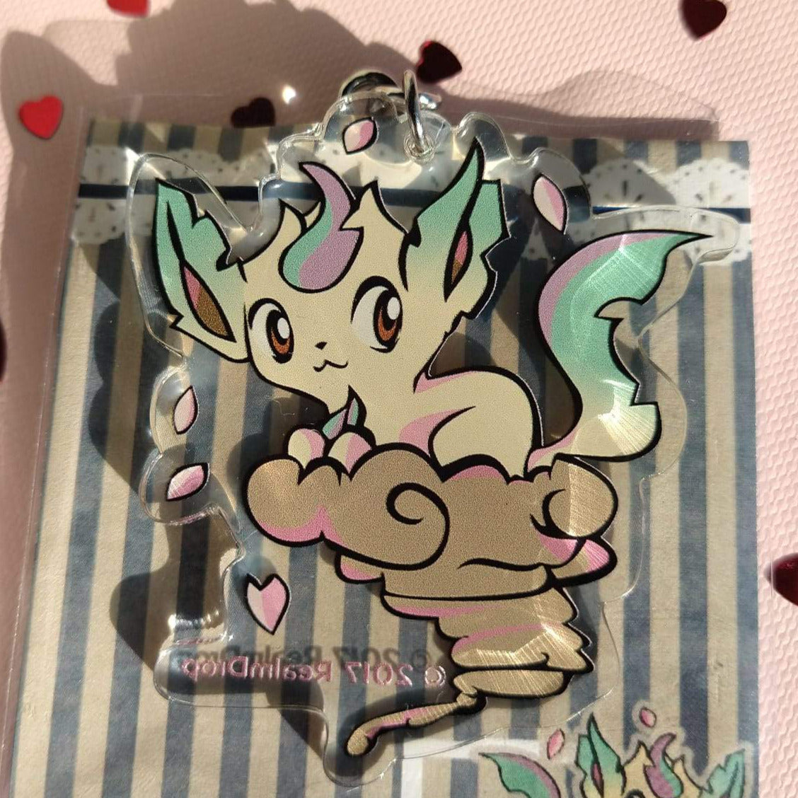 Acrylic Leafeon keychain on a brown whirlwind cloud with pink falling petals