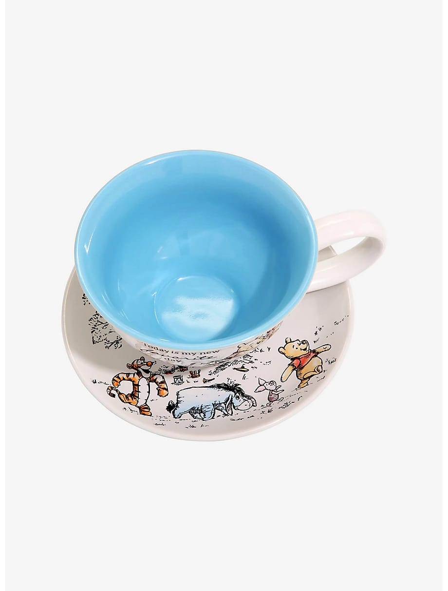 Top view of the Pooh teacup on its saucer showing the blue inside and character sketches
