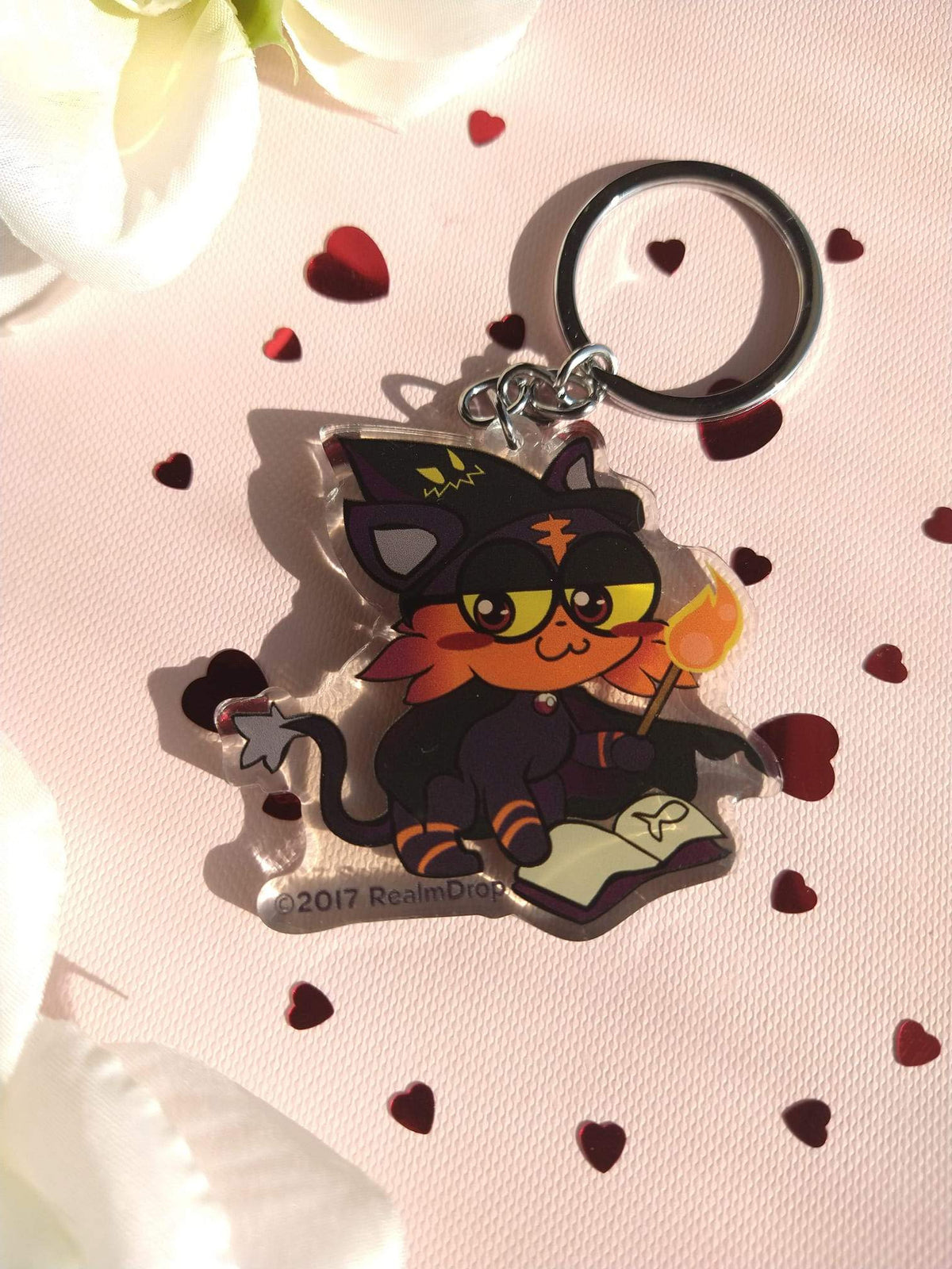 Acrylic Litten keychain as a witch with a hat, glasses, spellbook and flaming wand