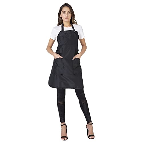 Woman in a black bib salon apron with two front pockets over a white tee