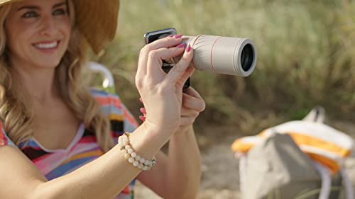 Woman at the beach holding the scope over a phone camera