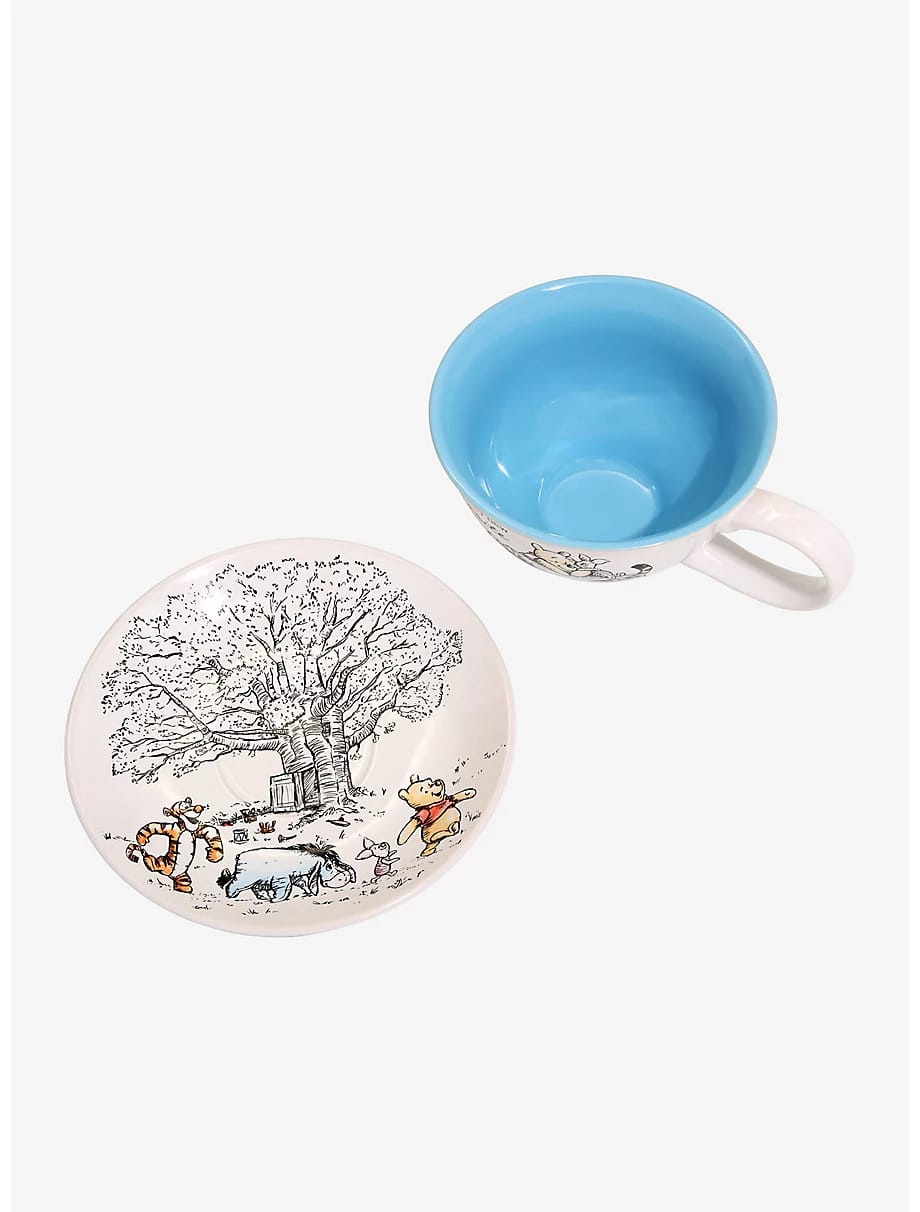 Pooh saucer with a sketched tree, Tigger, Eeyore and Piglet beside the blue-lined cup