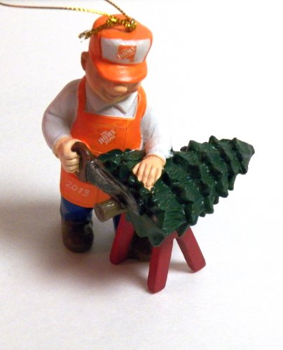 Figure in an orange apron and cap sawing a small Christmas tree, dated 2015