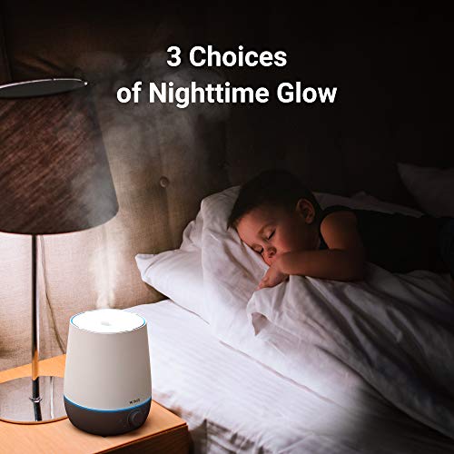 Humidifier glowing blue on a bedside table beside a sleeping child