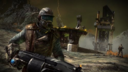 Soldier in a gas mask and helmet holding a rifle near a drilling rig