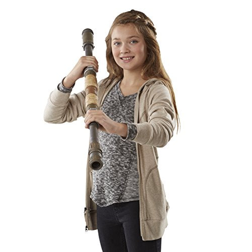 Smiling girl holding Rey's staff upright with both hands
