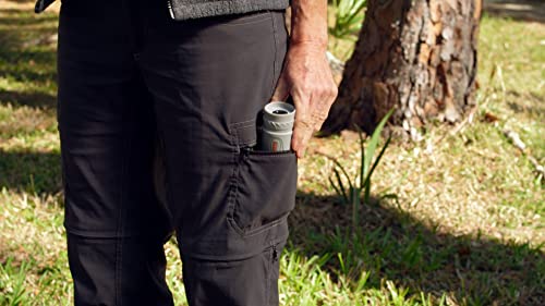 Hand slipping the compact scope into a cargo pants pocket