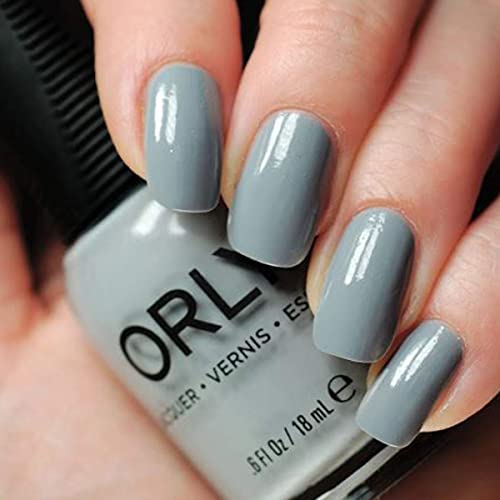 Glossy slate grey polish on nails held against the bottle