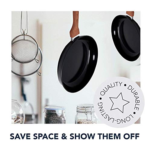 Two black frying pans hanging in a kitchen: save space and show them off